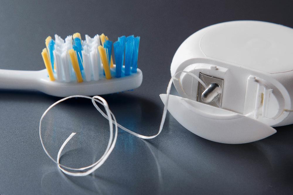 close up of floss and toothbrush | Gum Disease Treatment fishers in